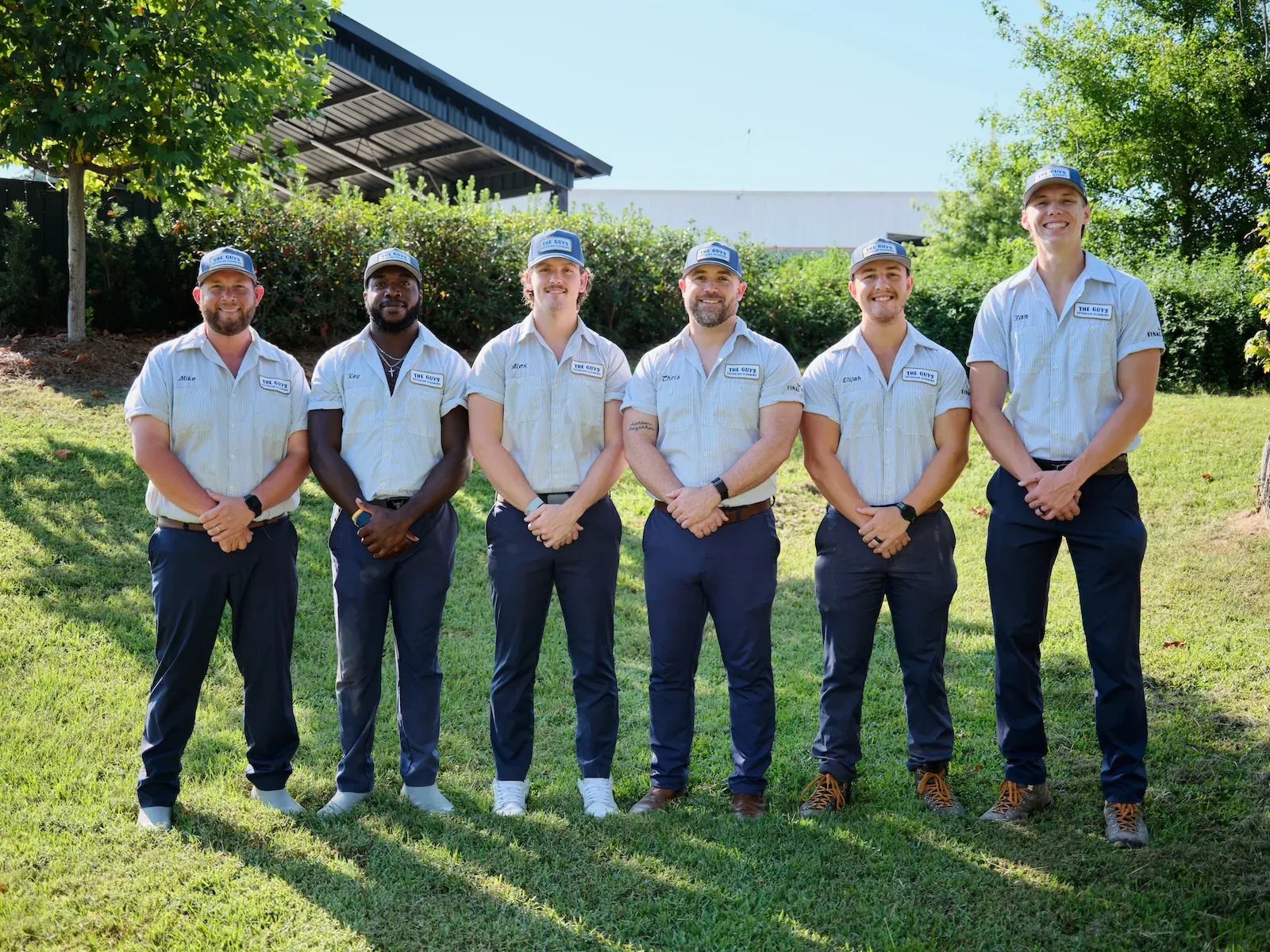 The Guys Exterior Cleaning team — Mike, Key, Alex, Chris, Elijah, and Ian — in matching uniforms standing together outdoors in Madison, MS