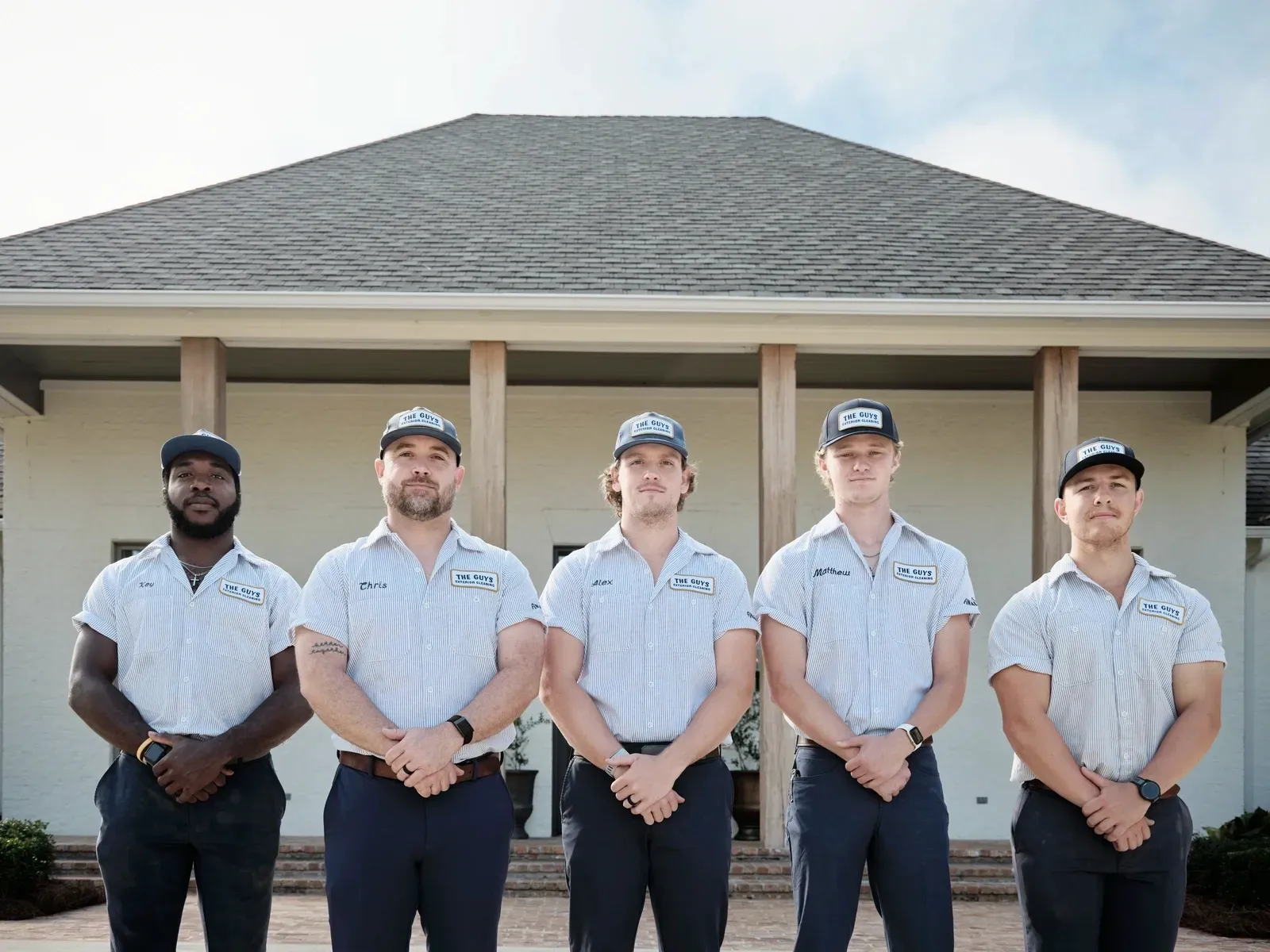 The Guys Exterior Cleaning team — Chris, Alex, Key, Matthew, and Elijah — in matching uniforms standing in front of a Ridgeland, MS home