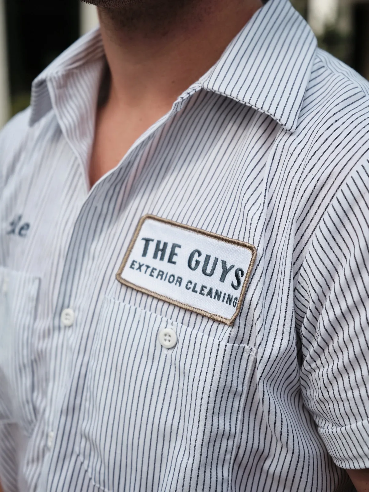 The Guys Exterior Cleaning employee in a branded uniform